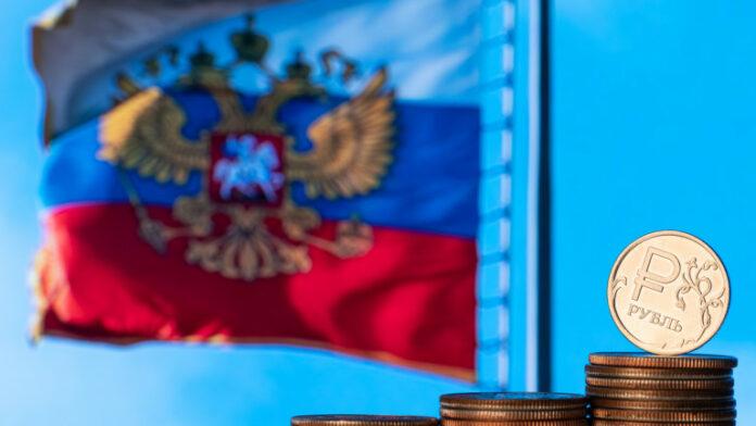 Coins with the symbol of the Russian ruble on the background of the Russian flag