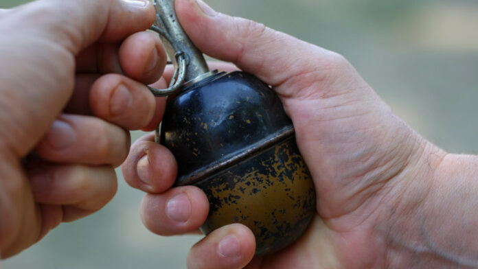 Antipersonnel grenade in men's hands close up